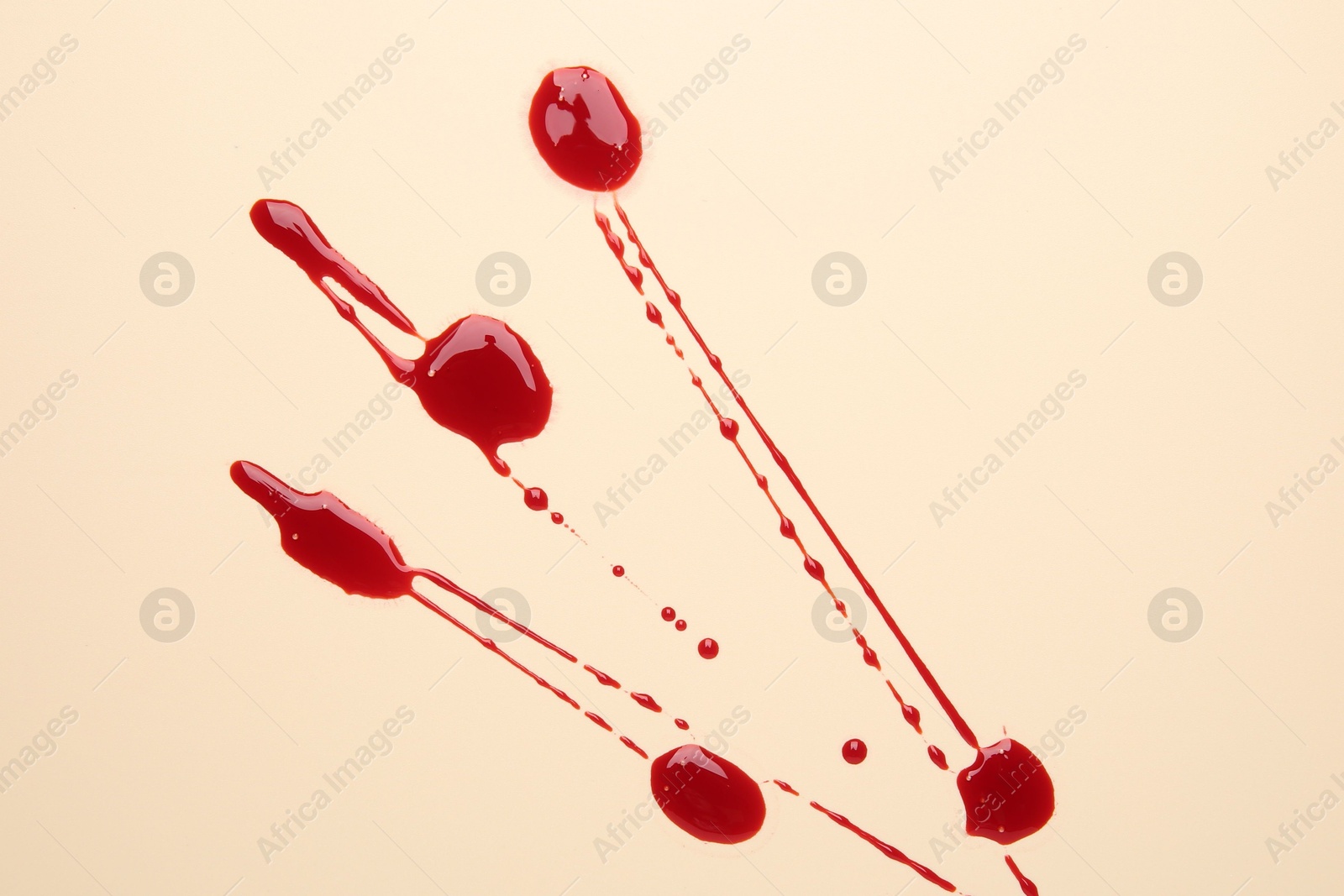 Photo of Splashes of blood on beige background, top view