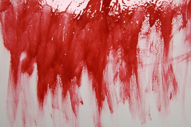 Red blood on light grey background, top view