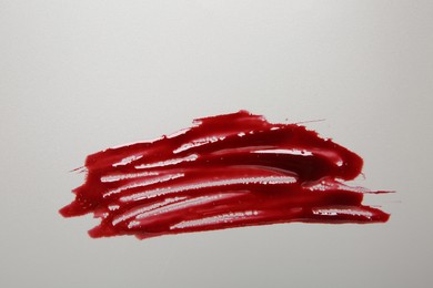 Stain of blood on light grey background, top view