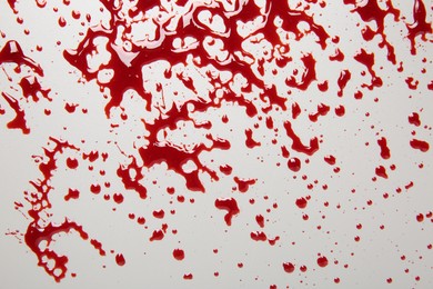 Photo of Splashes of blood on light grey background, top view