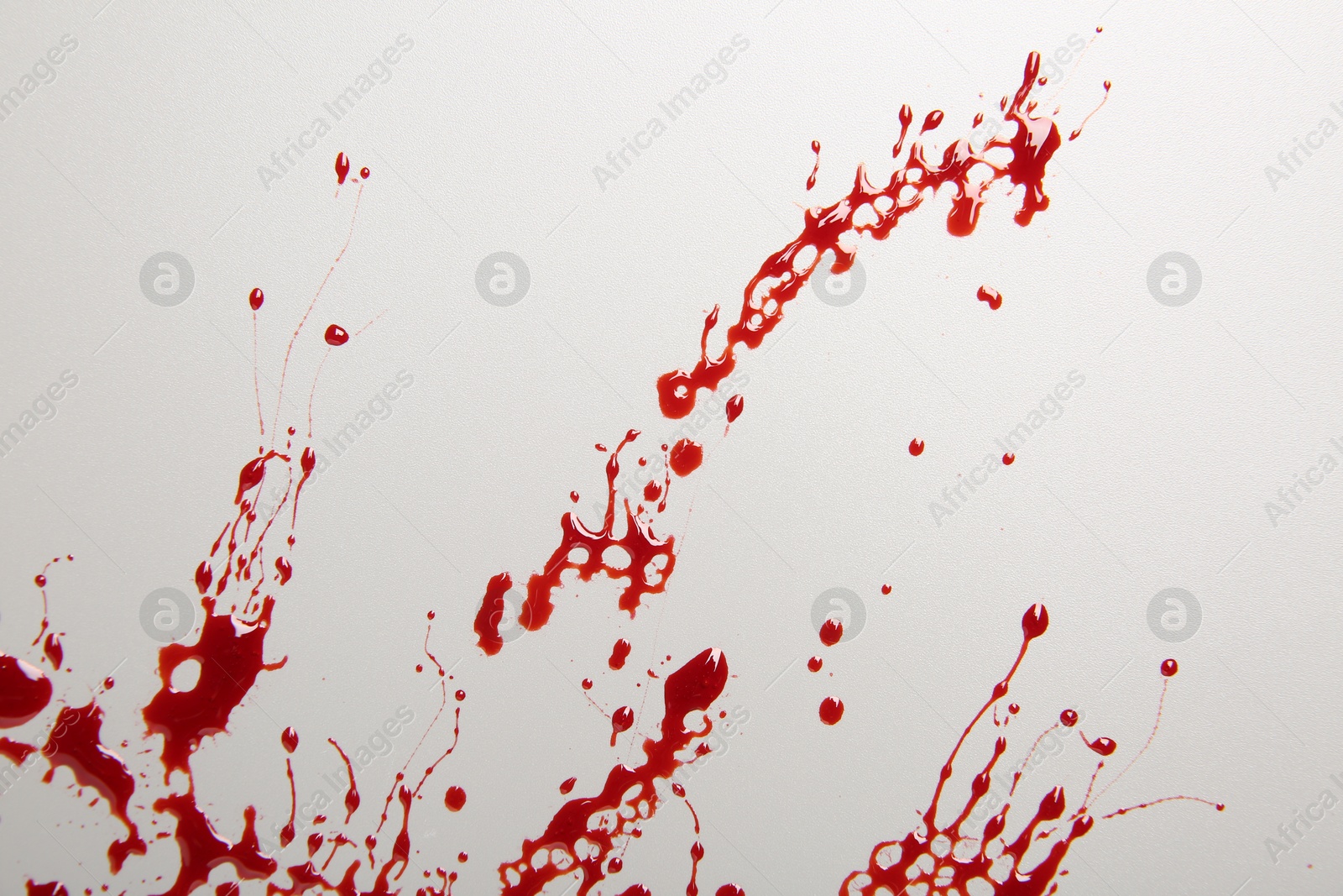 Photo of Splashes of blood on light grey background, top view