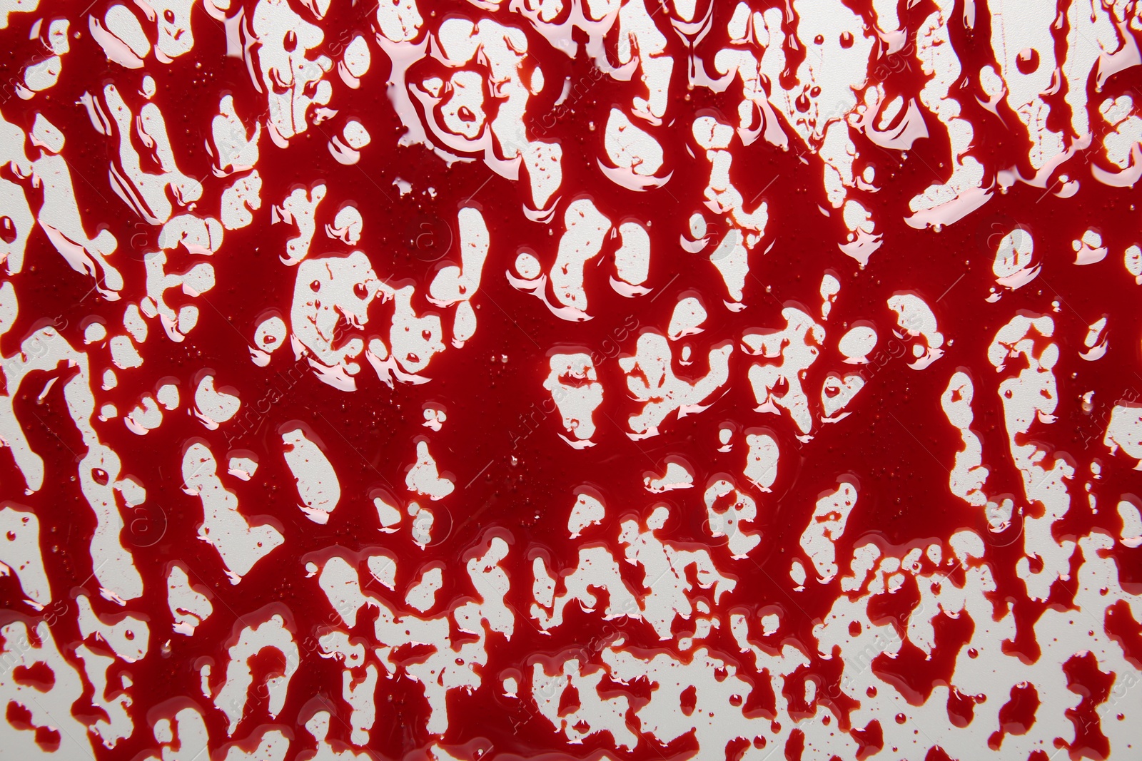 Photo of Splashes of blood on light background, top view