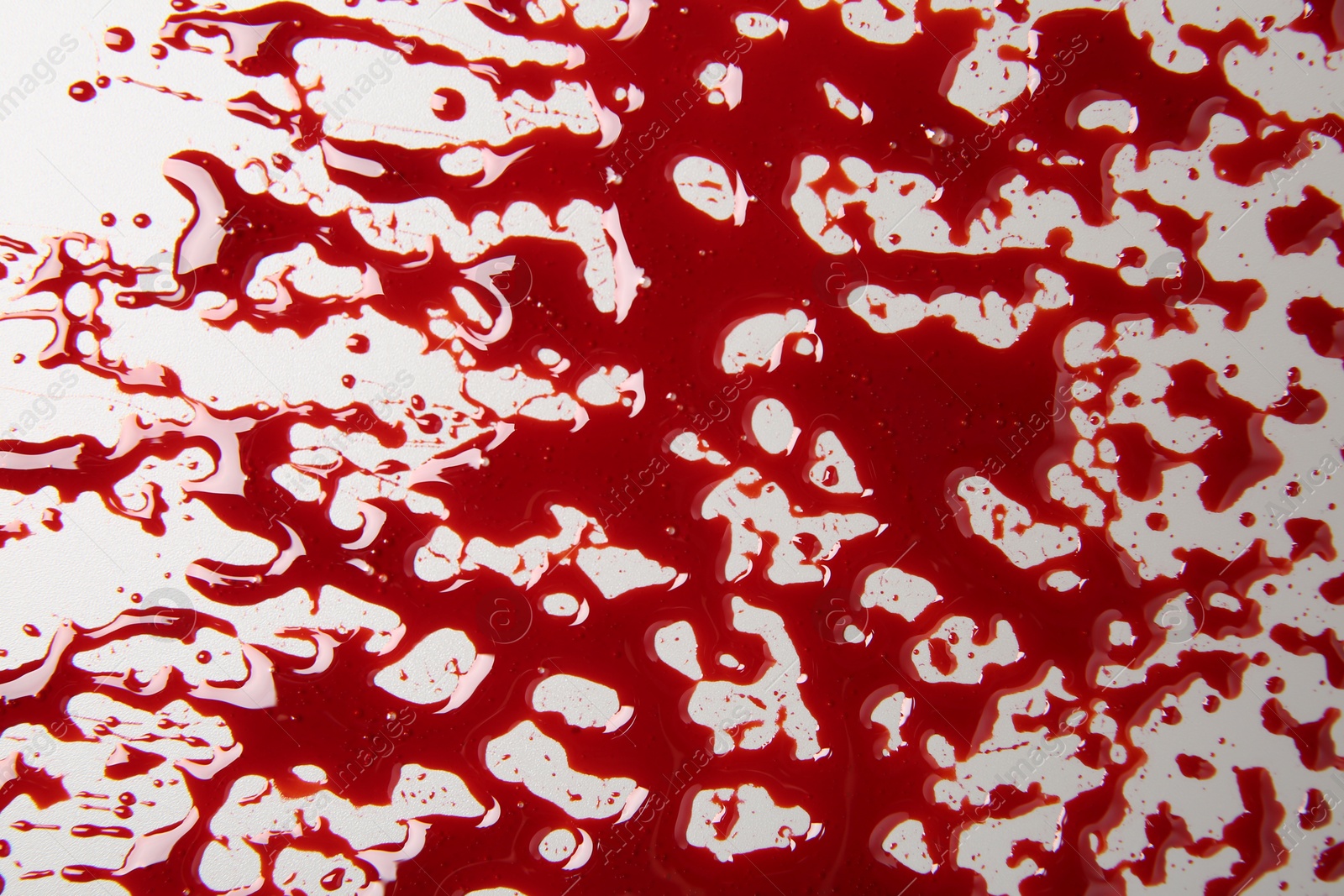 Photo of Splashes of blood on light background, top view