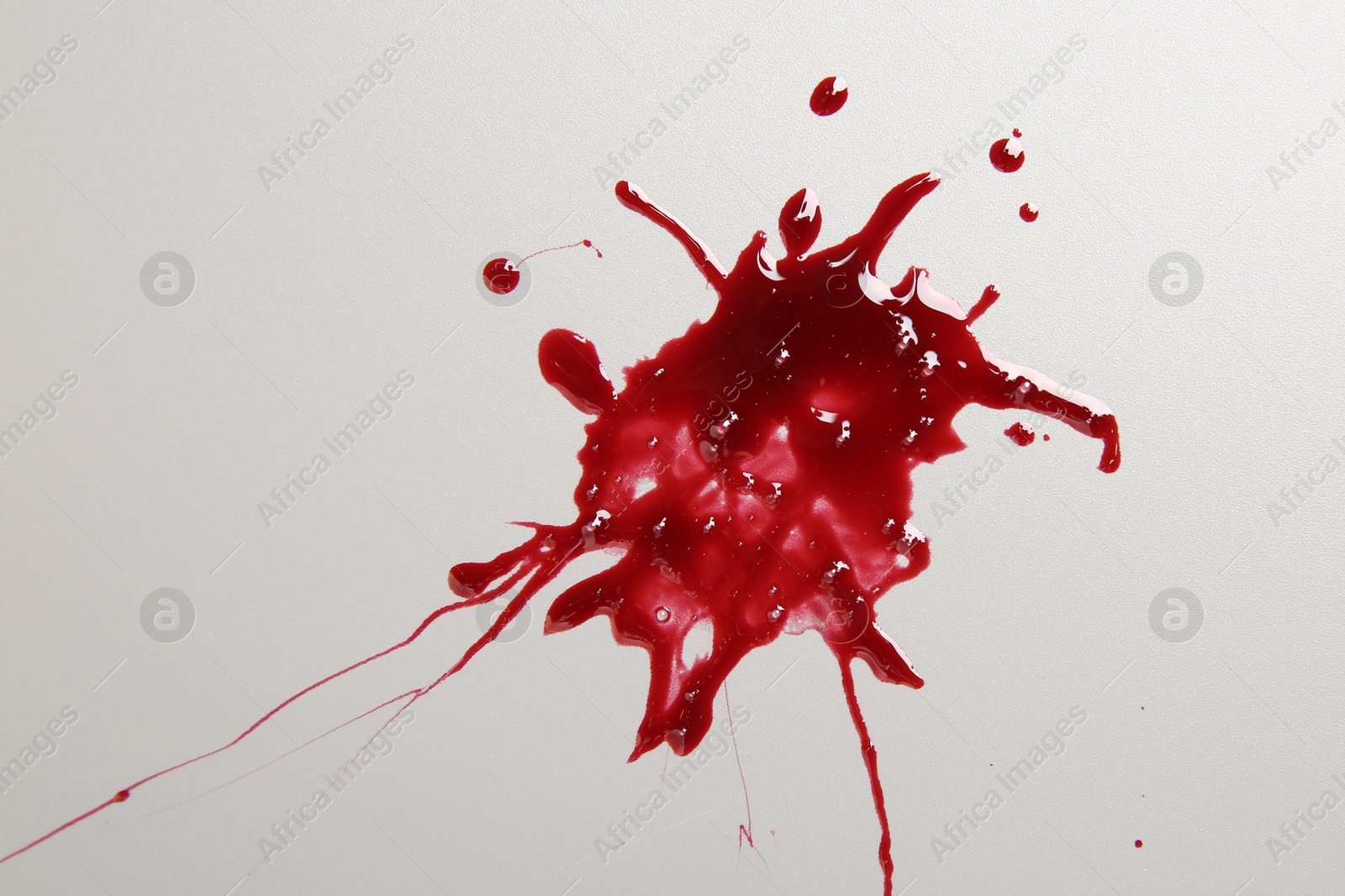 Photo of Splashes of blood on light grey background, top view