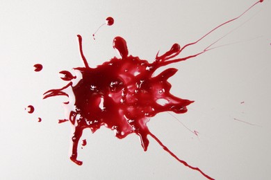 Splashes of blood on light grey background, top view