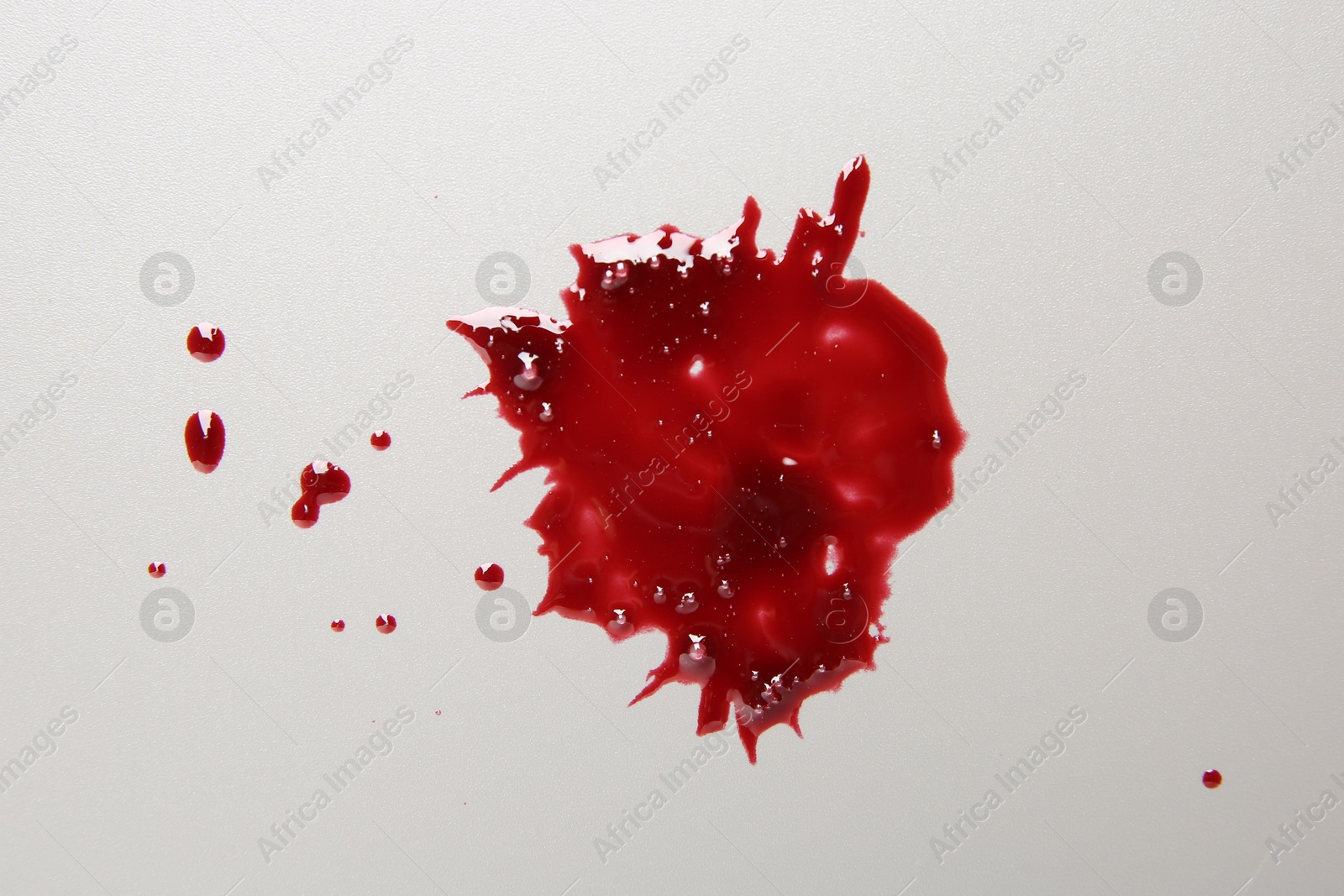 Photo of Splashes of blood on light grey background, top view