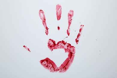 Photo of Bloody handprint on light background, top view