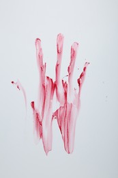 Photo of Bloody handprint on light background, top view