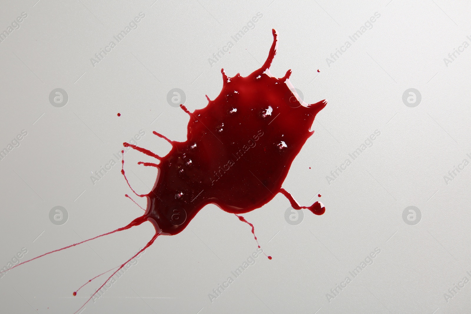 Photo of Stain of blood on light grey background, top view