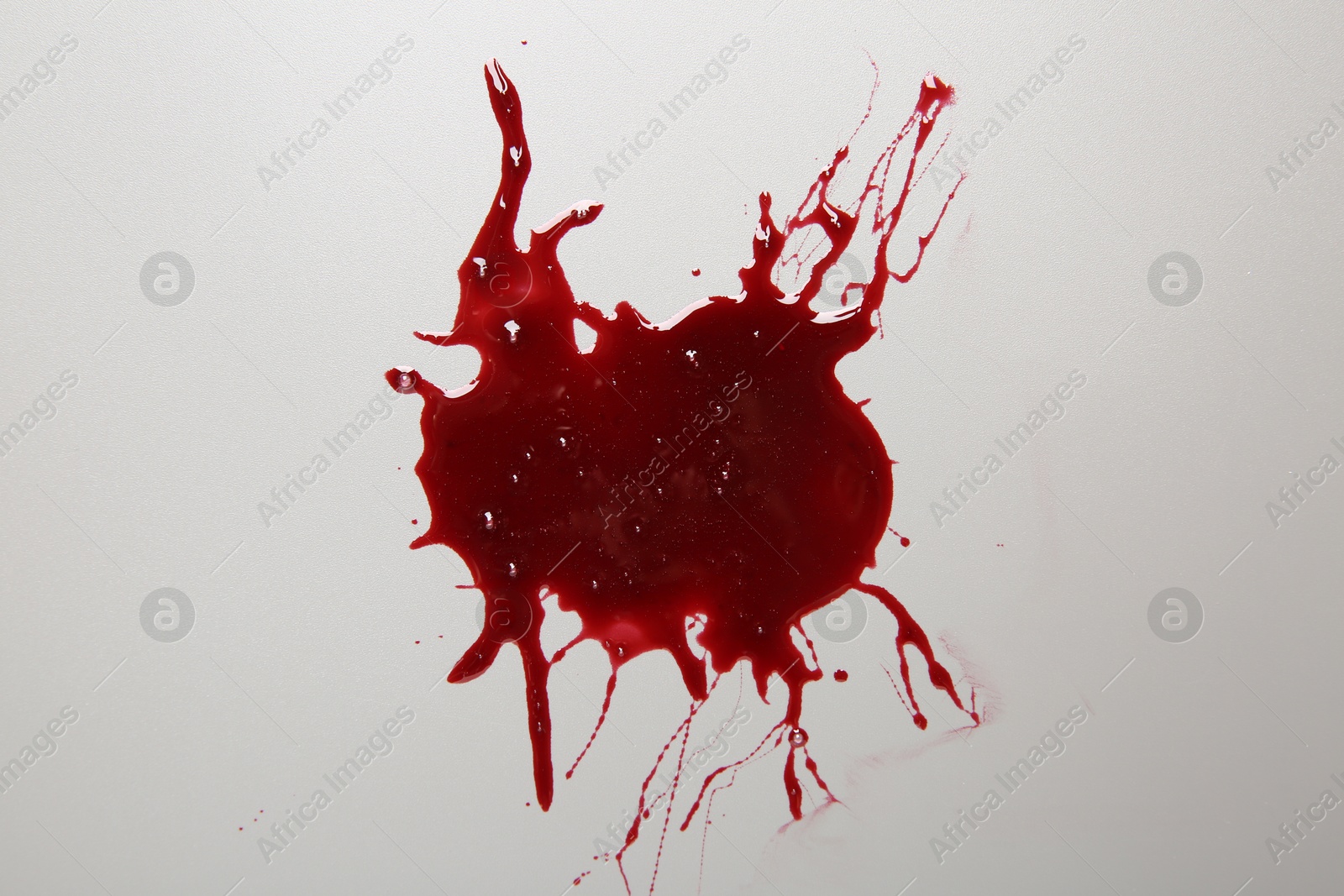 Photo of Stain of blood on light grey background, top view