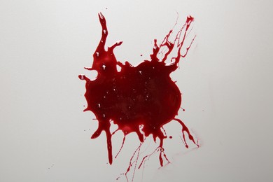 Stain of blood on light grey background, top view