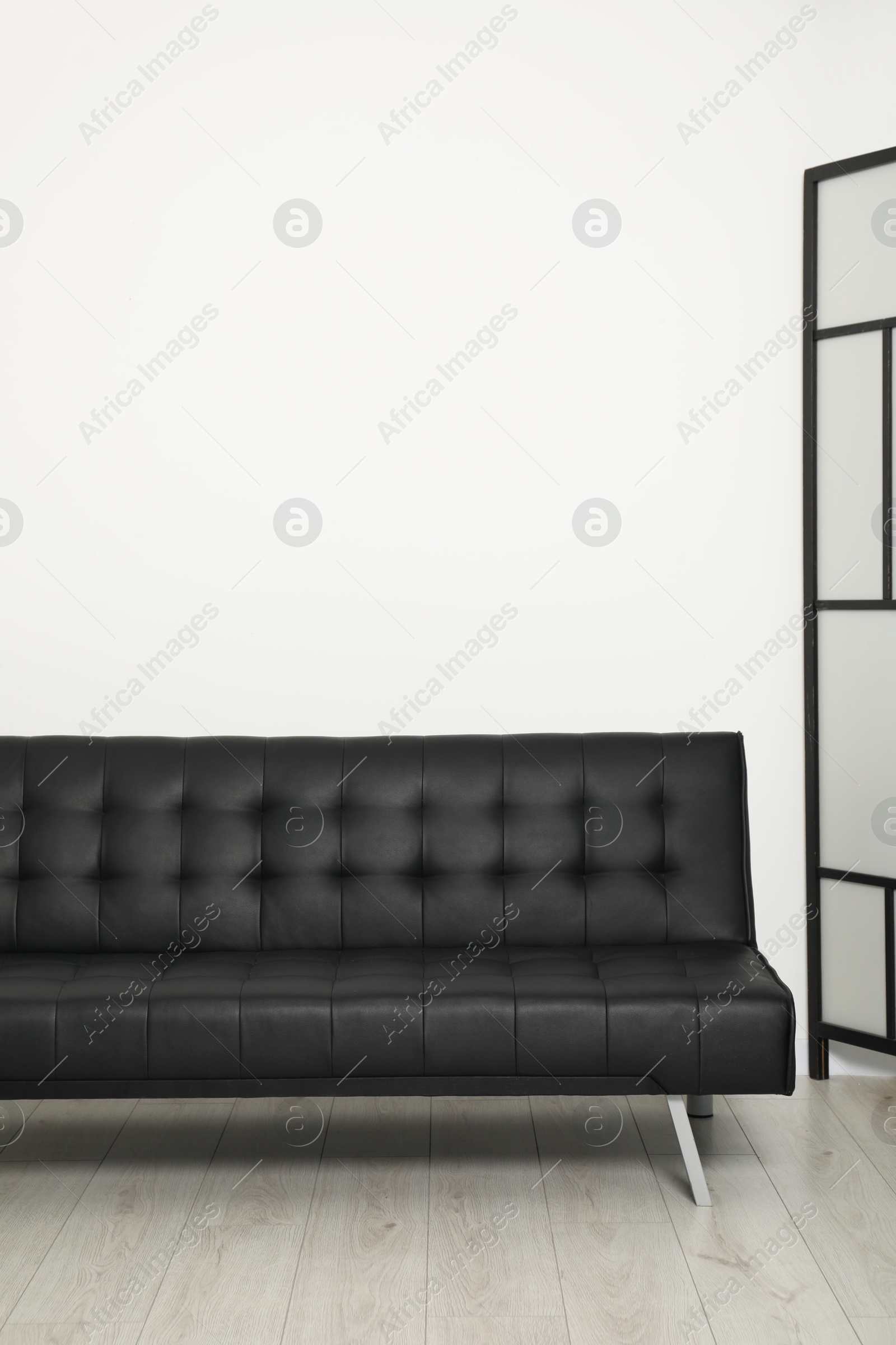 Photo of Comfortable couch near white wall. Interior design