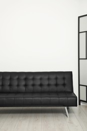 Photo of Comfortable couch near white wall. Interior design