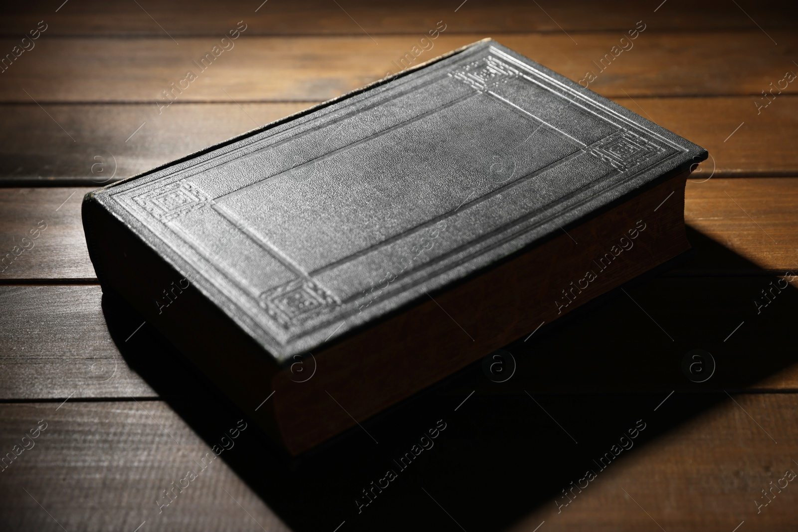 Photo of Closed Bible on wooden table. Christian faith