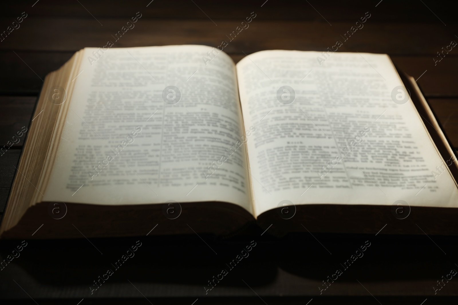 Photo of Open Bible on wooden table, closeup. Christian faith