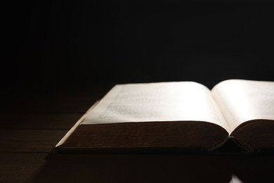 Open Bible on wooden table, closeup. Christian faith