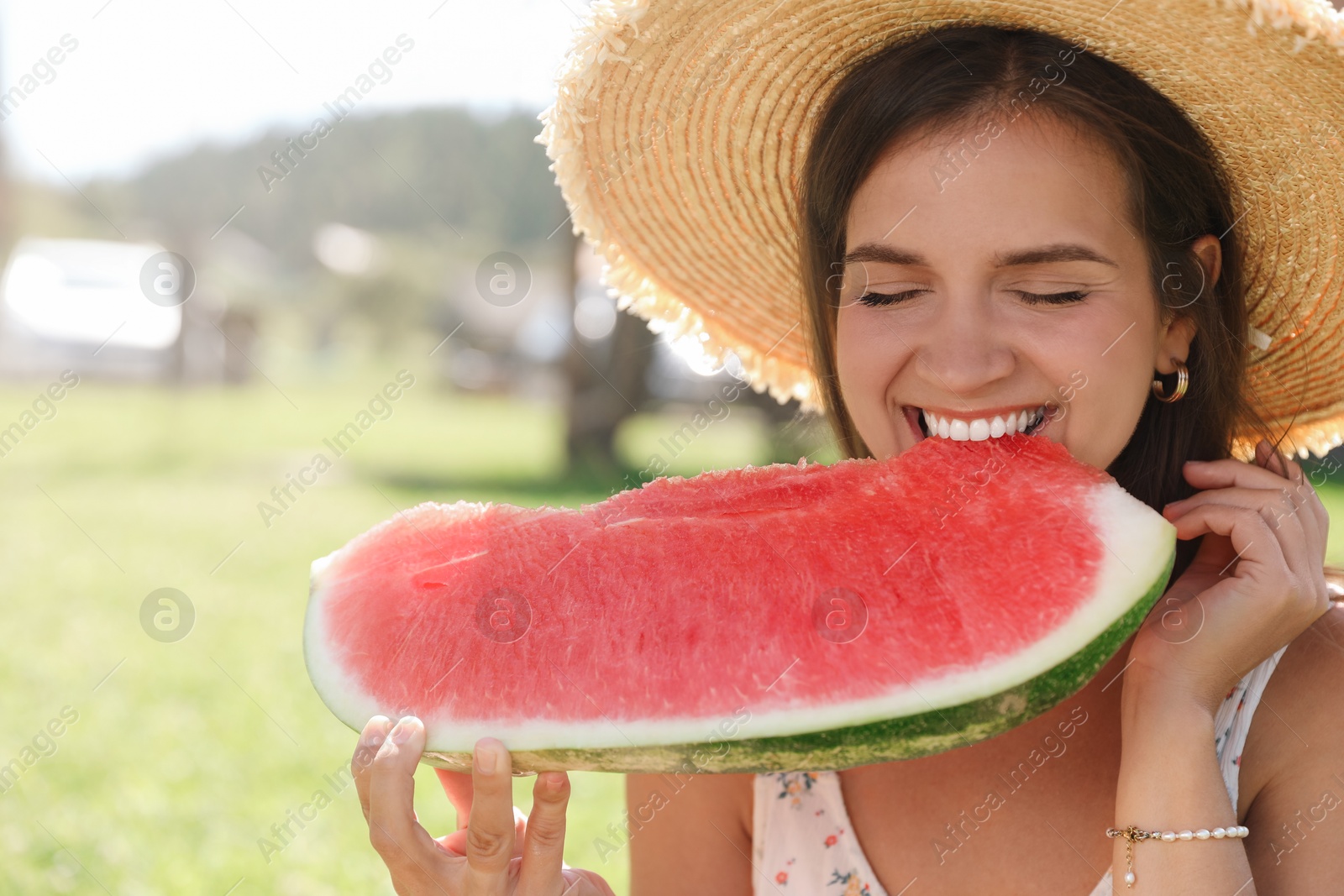 Photo of Happy woman eating fresh juicy watermelon outdoors