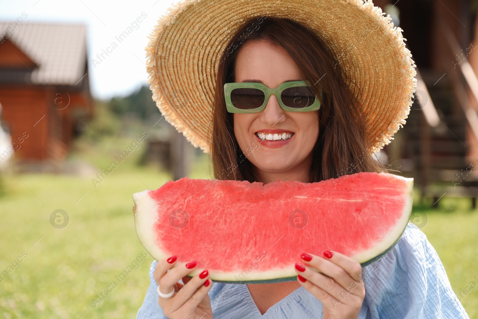 Photo of Happy woman with slice of juicy watermelon outdoors