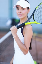 Beautiful woman with tennis racket on court