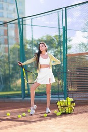 Beautiful woman with tennis racket on court