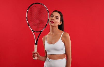 Photo of Beautiful young woman with tennis racket on red background