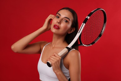 Photo of Beautiful young woman with tennis racket on red background