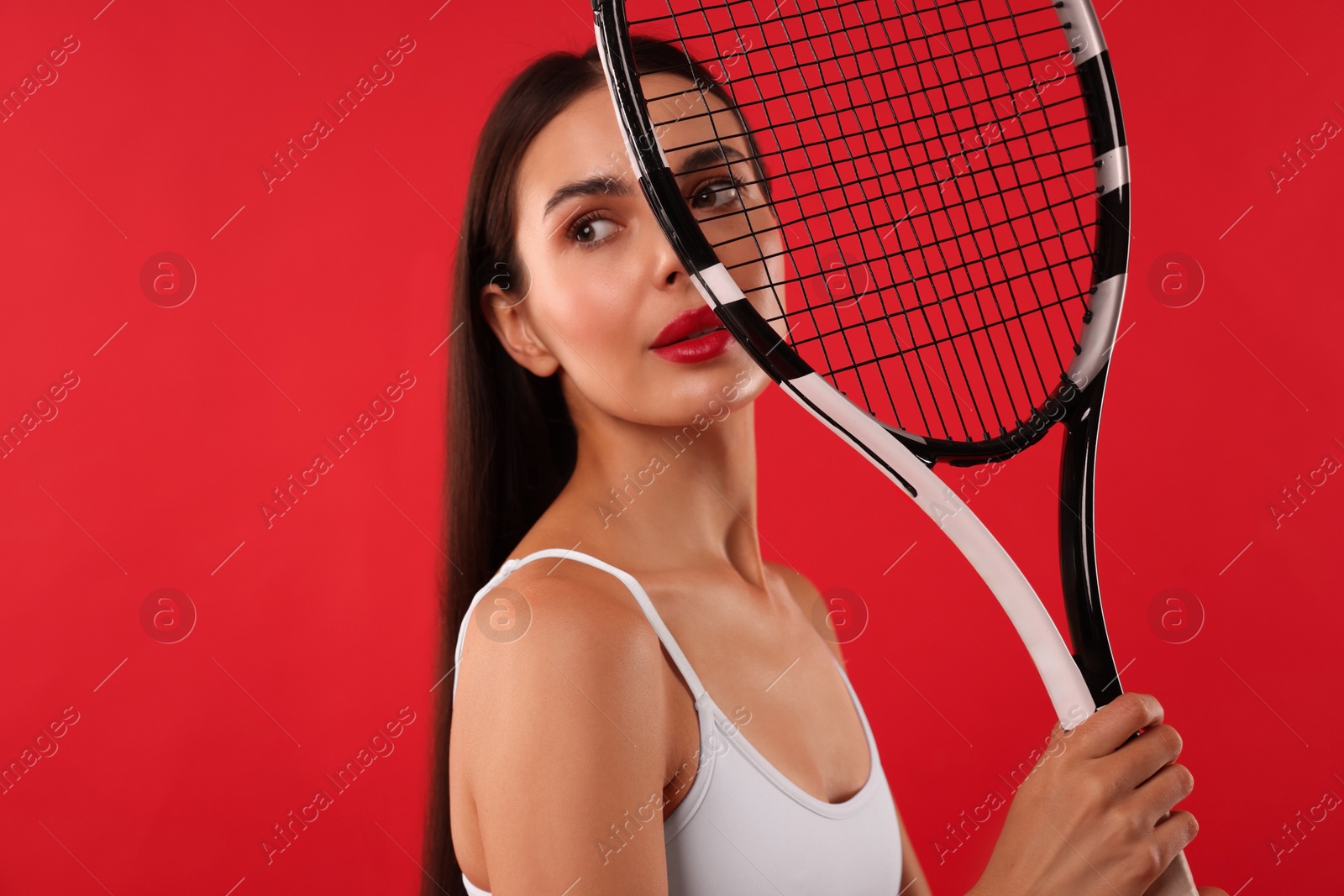 Photo of Beautiful young woman with tennis racket on red background