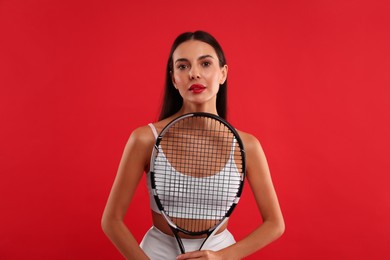 Photo of Beautiful young woman with tennis racket on red background