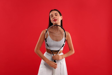 Photo of Beautiful young woman with tennis racket on red background