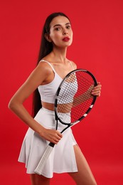 Photo of Beautiful young woman with tennis racket on red background