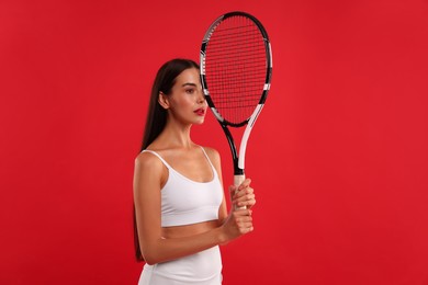 Photo of Beautiful young woman with tennis racket on red background