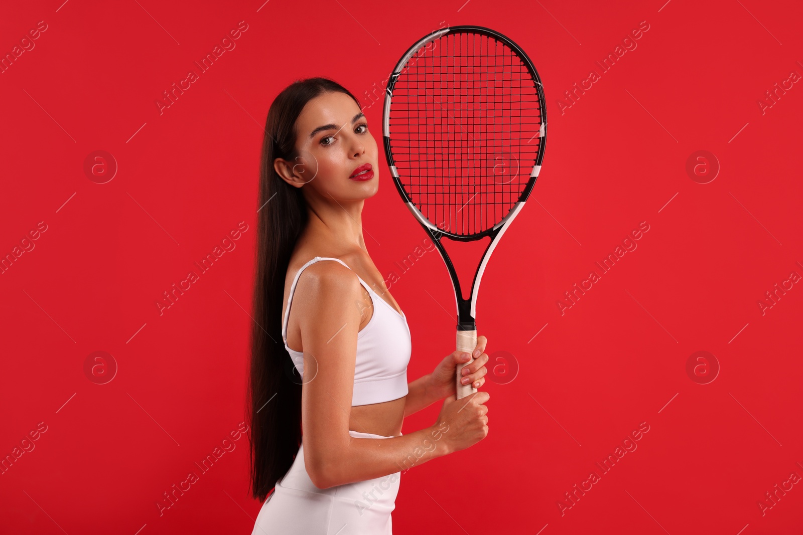 Photo of Beautiful young woman with tennis racket on red background