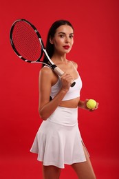 Tennis player with racket and ball on red background