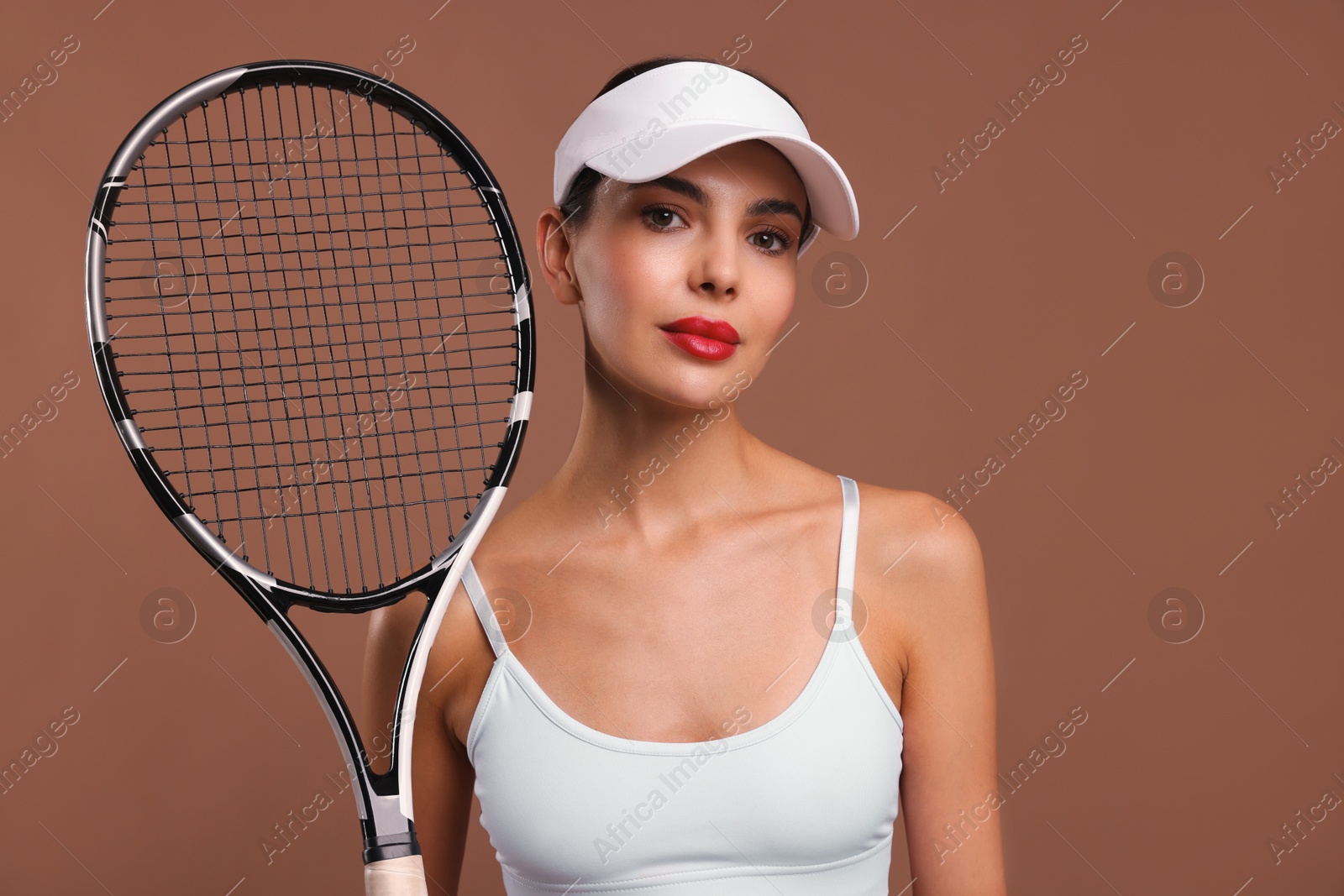 Photo of Beautiful young woman with tennis racket on brown background