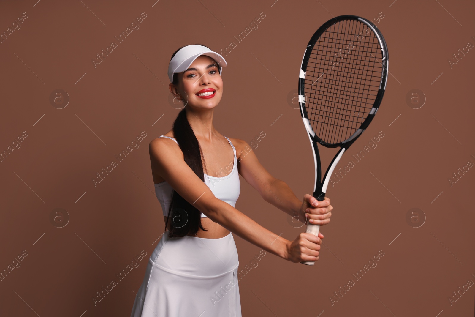 Photo of Beautiful young woman with tennis racket on brown background