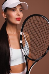 Photo of Beautiful young woman with tennis racket on brown background