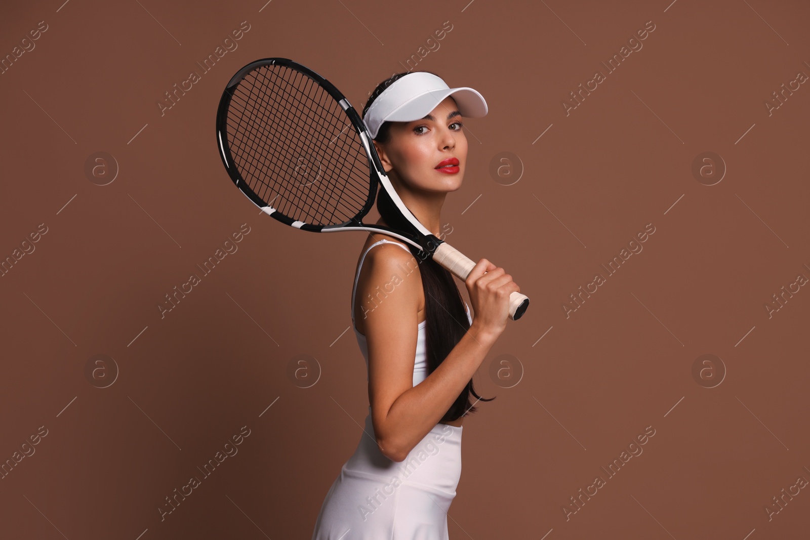 Photo of Beautiful young woman with tennis racket on brown background