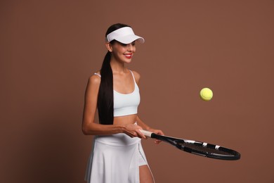 Photo of Happy tennis player with racket and ball on brown background