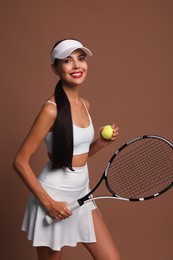 Happy tennis player with racket and ball on brown background