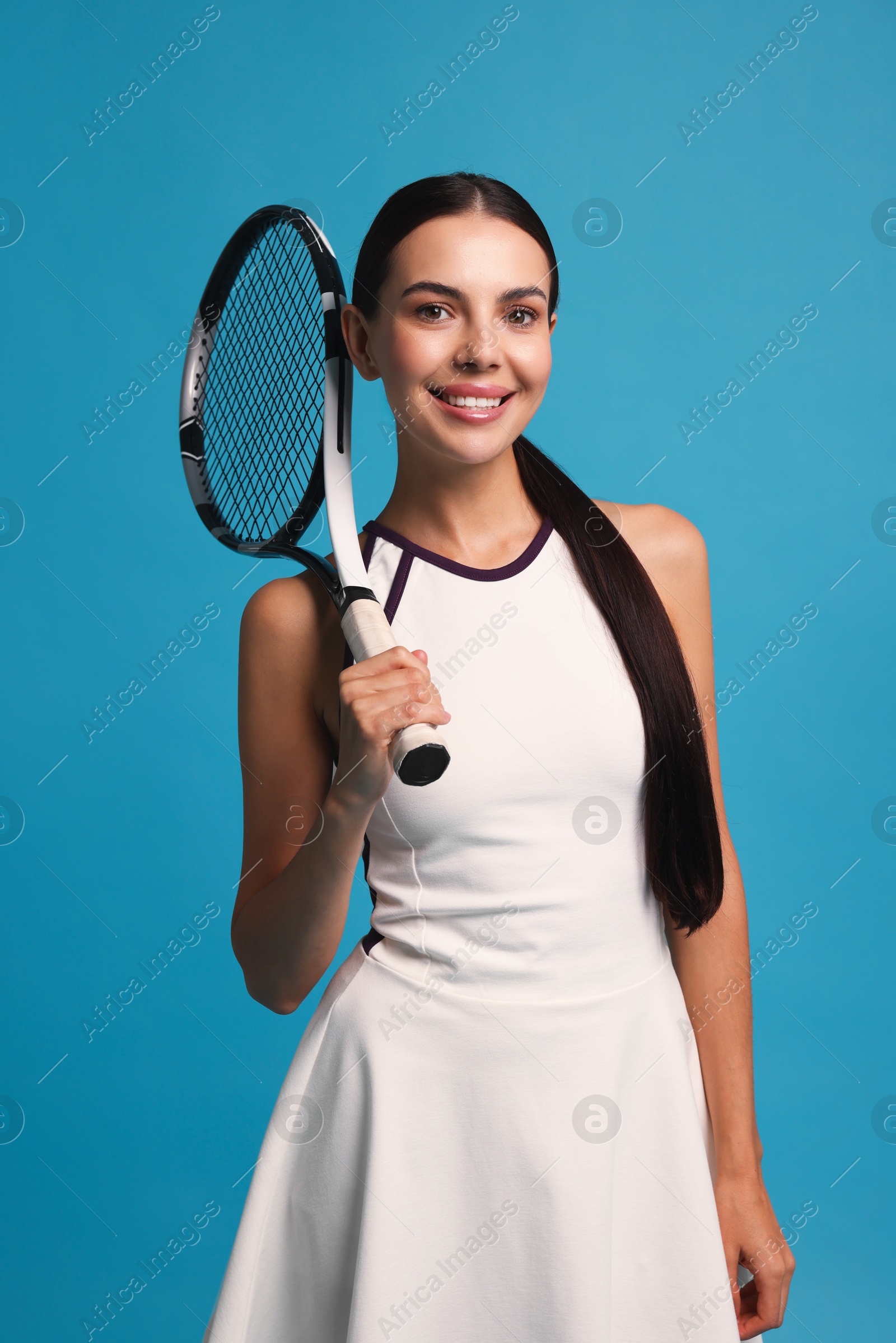 Photo of Beautiful young woman with tennis racket on light blue background