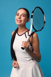 Beautiful young woman with tennis racket on light blue background