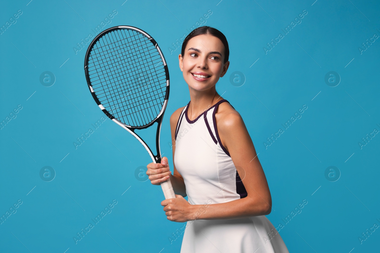 Photo of Beautiful young woman with tennis racket on light blue background