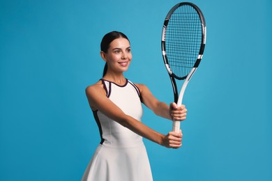 Photo of Beautiful young woman with tennis racket on light blue background