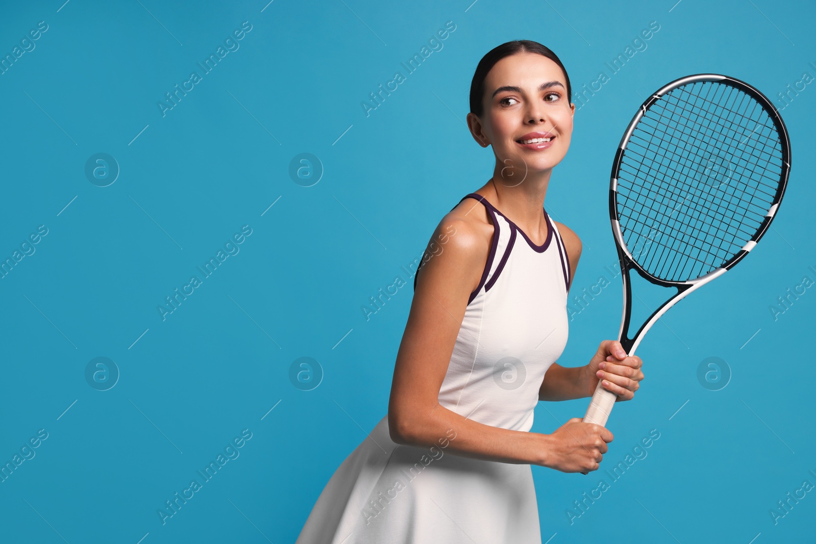 Photo of Beautiful young woman with tennis racket on light blue background, space for text