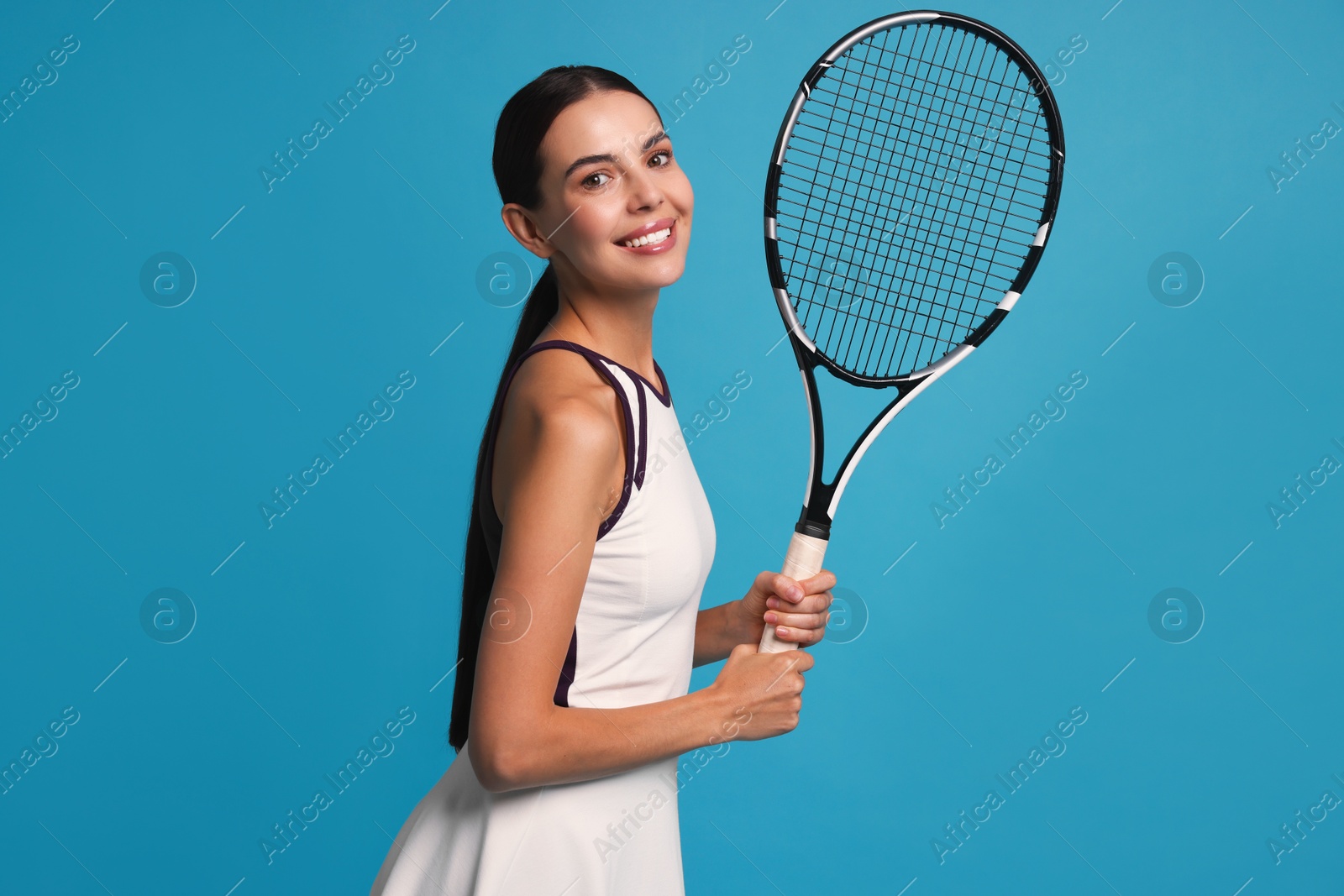 Photo of Beautiful young woman with tennis racket on light blue background