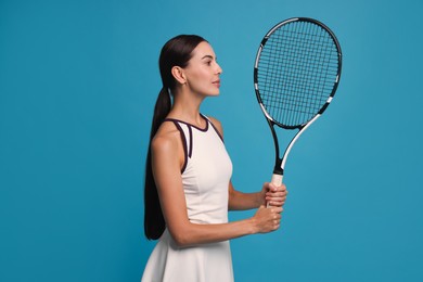 Photo of Beautiful young woman with tennis racket on light blue background