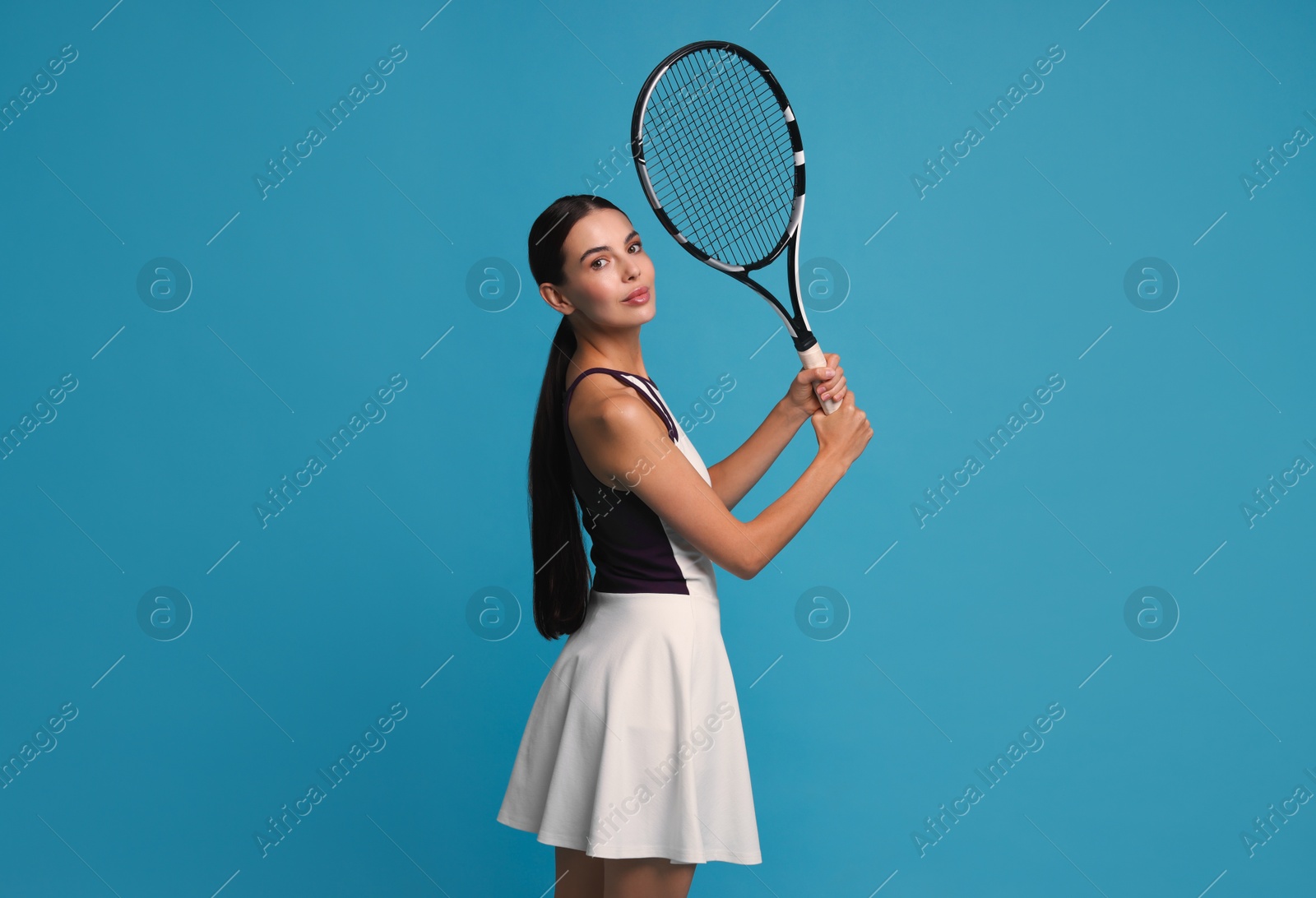 Photo of Beautiful young woman with tennis racket on light blue background