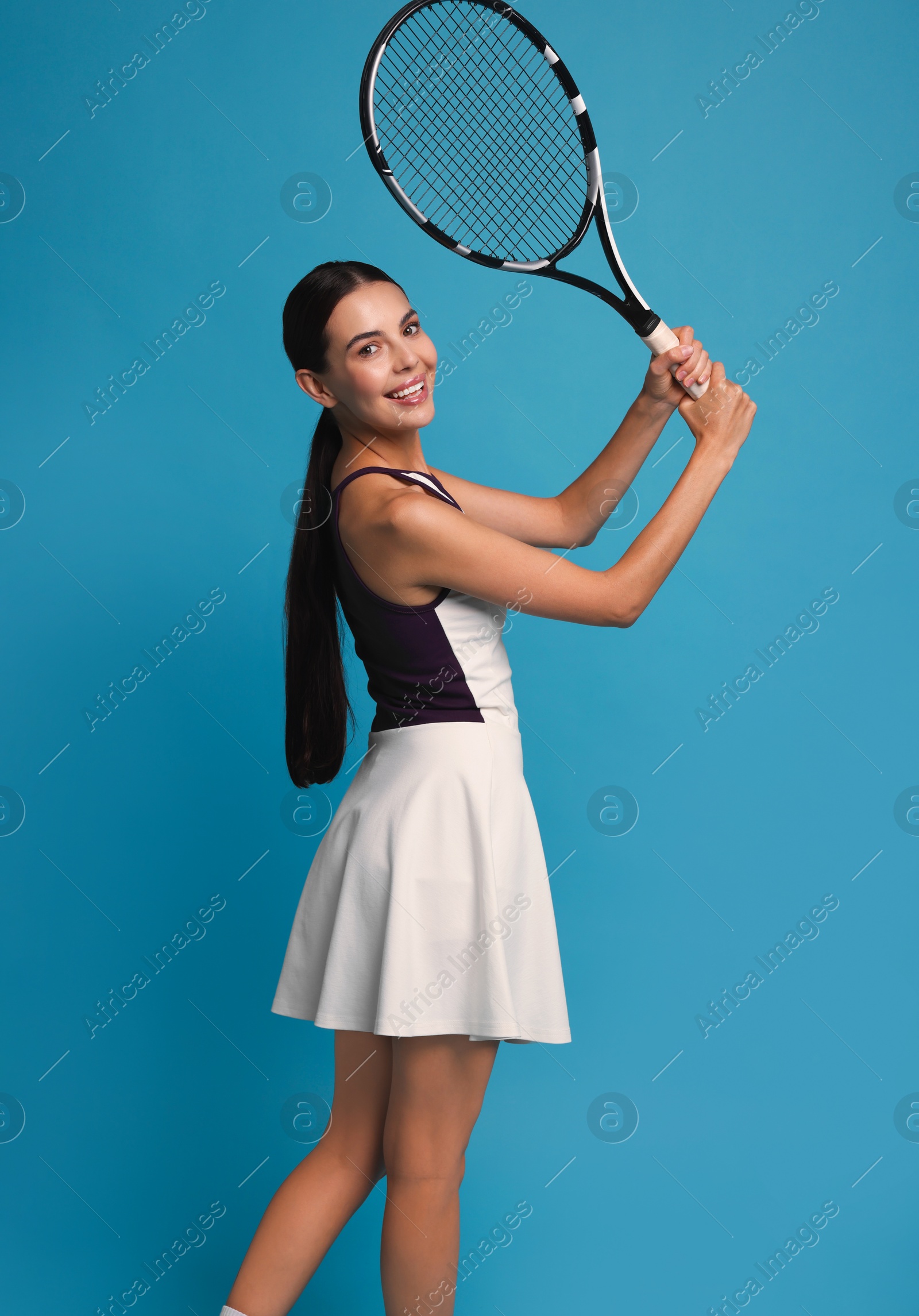 Photo of Beautiful young woman with tennis racket on light blue background