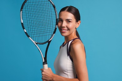 Photo of Beautiful young woman with tennis racket on light blue background