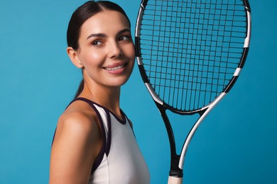 Photo of Beautiful young woman with tennis racket on light blue background